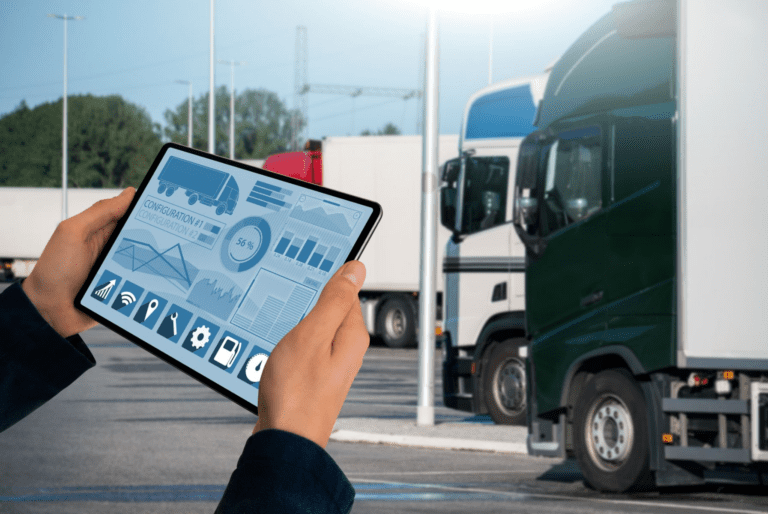 A tablet displaying data with trucks in the background.